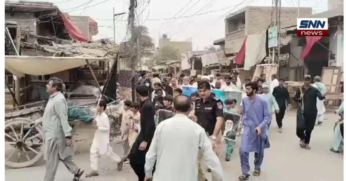 Shia men and women protesting in Jacobabad against US and Israeli aggression on Iran, holding banners and chanting slogans.