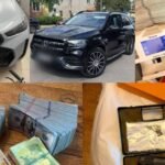 Seized luxury cars, cash bundles, and documents during a Ukraine corruption investigation involving senior police officials.