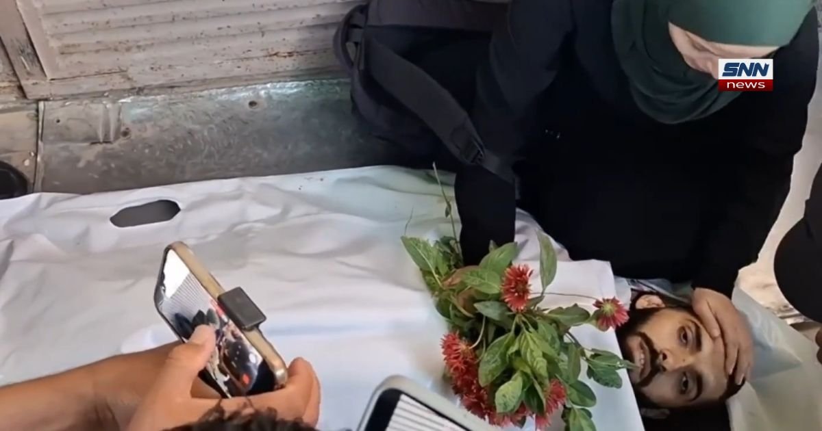 Al Jazeera journalist Ahmad Washah sister mourning beside his body at funeral in Gaza after Israeli airstrike on Al-Bureij camp