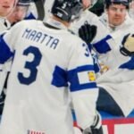 Finland players celebrate after defeating Switzerland 1-0 in the 2026 Ice Hockey World Championship final and lifting the trophy.