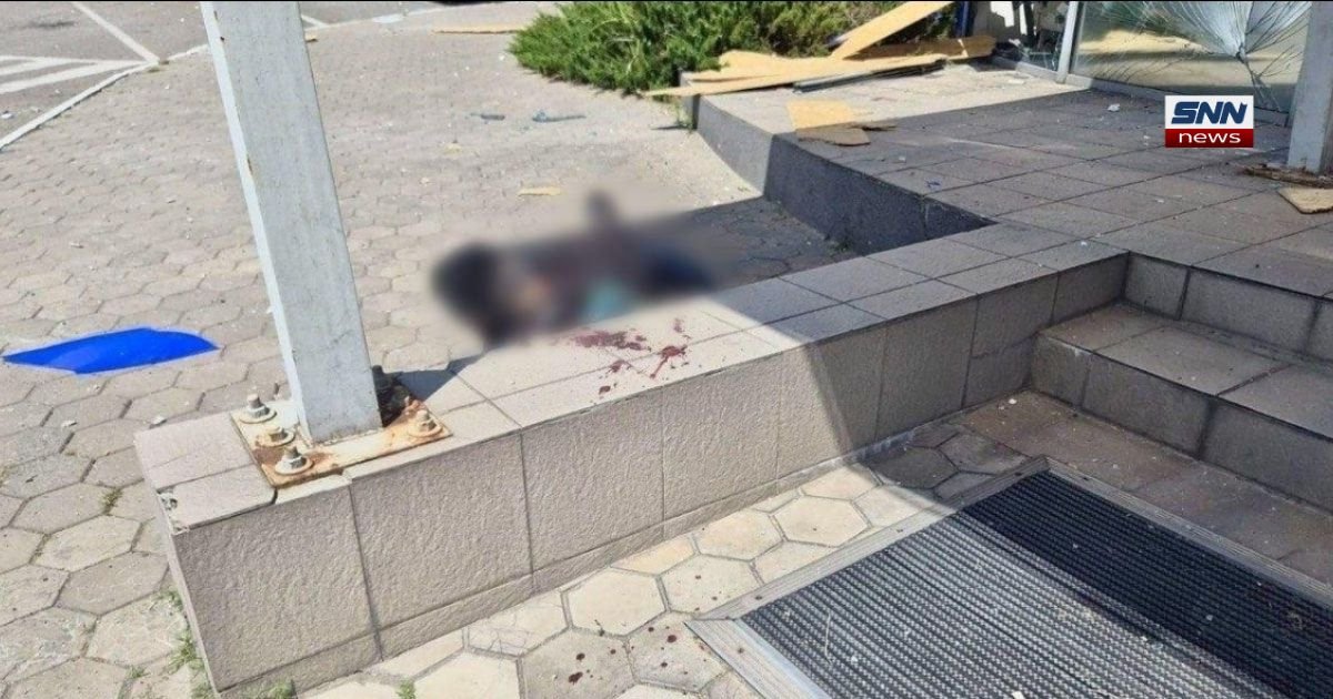 Aftermath of military strikes across showing damage and a casualty near a building entrance in Ukraine