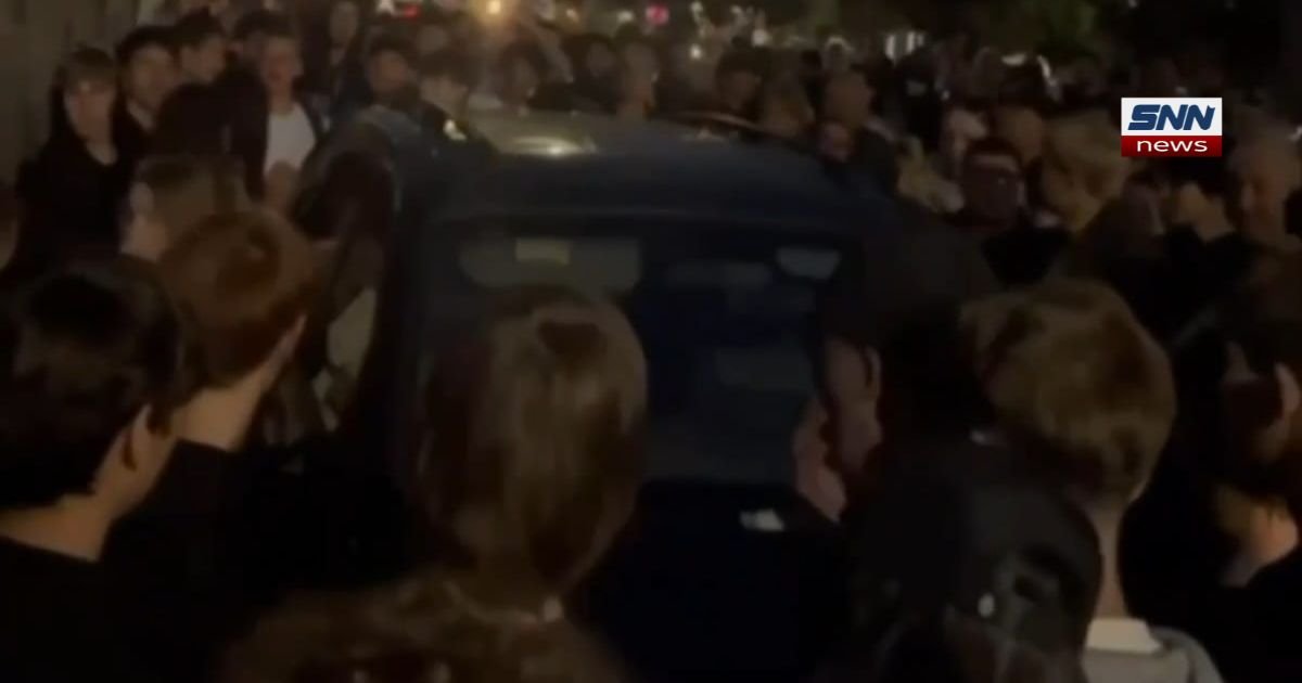 Crowd surrounds overturned Ukrainian military recruitment vehicle during anti-mobilization protest in Lviv, July 2026