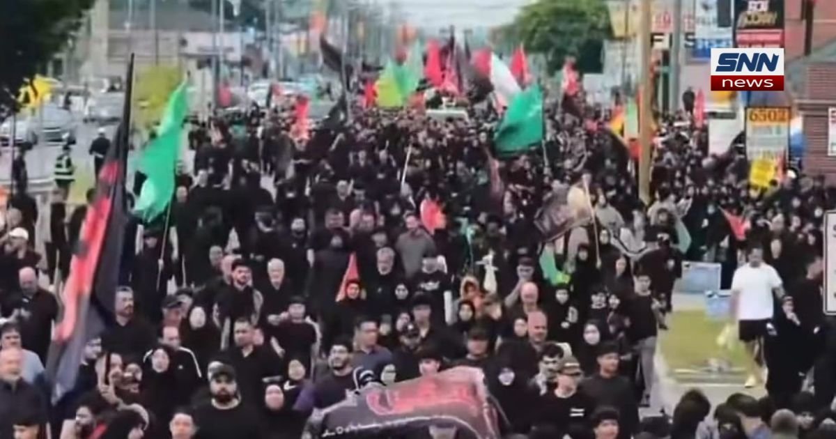 Thousands of Shia Muslims march with flags during the 2026 Arbaeen procession in Dearborn, Michigan"