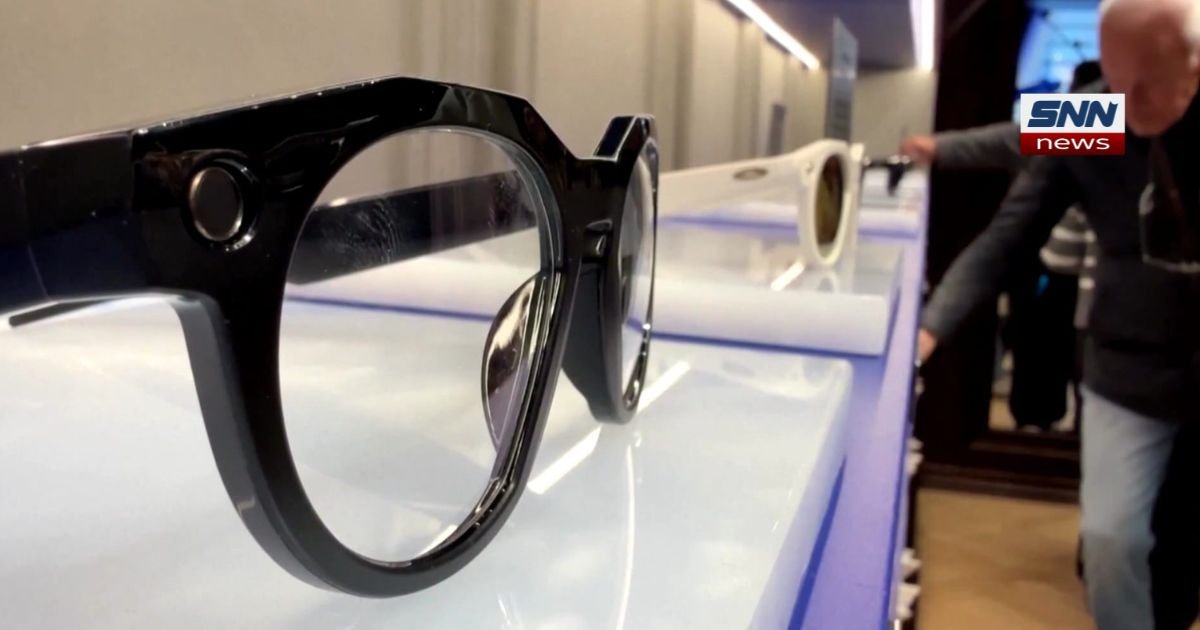 Close-up of smart glasses with a built-in camera lens near the frame hinge"