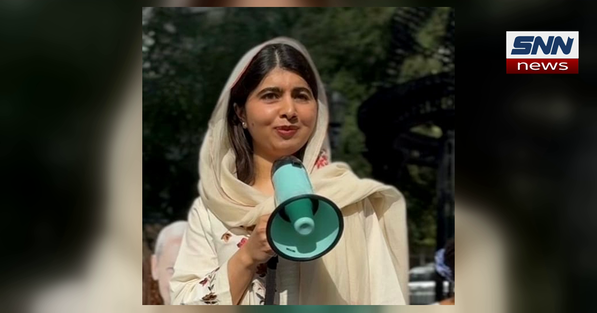 Malala Yousafzai speaking into a megaphone at a public event